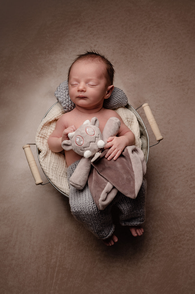 marine brun bébé dans un panier sécurisé, séance naissance professionnelle Coutras