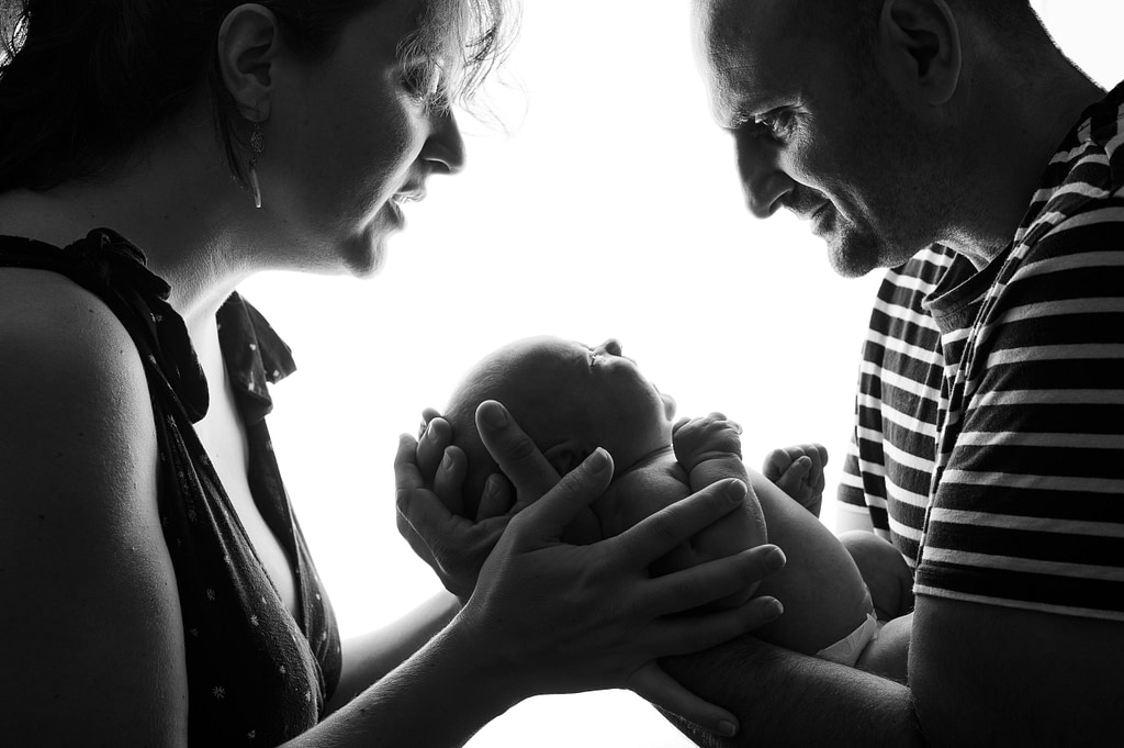 parents tenant leur nouveau-né en position sécurisée marine brun